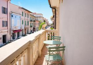 a balcony with a table and chairs on a street at Mare di Gioia in Viareggio