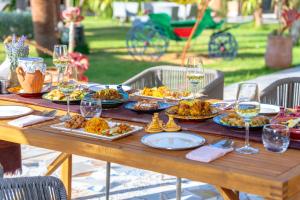 a table with plates of food and glasses of wine at Jnane Rihane Marrakech in Marrakesh
