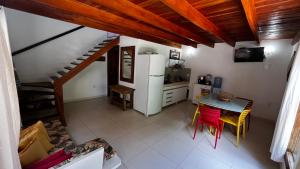 a kitchen with a refrigerator and a table and chairs at Chalé Paraíso Corumbau - Chalés Uvas Azul in Corumbau