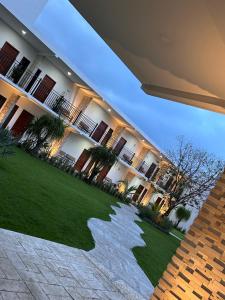 a large building with a green lawn in front of it at Hotel Casa del Rio in Santiago Tuxtla