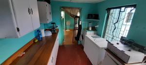 a kitchen with green walls and white cabinets at Guest house in Basseterre +2 photos