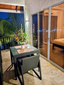 a table and chair in a room with a balcony at Hazel's Suites in Dauin
