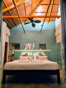 a bedroom with a bed with a ceiling fan at Hazel's Suites in Dauin