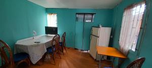 a kitchen with a table and chairs and a refrigerator at Guest house in Basseterre