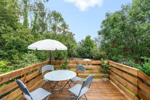 a table and chairs on a wooden deck with an umbrella at Downs Escape By My Getaways in Lancing