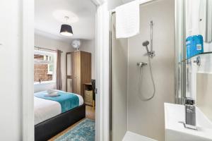 a bathroom with a shower and a bed and a tub at Downs Escape By My Getaways in Lancing +25 photos