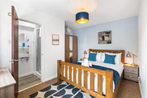 a bedroom with a wooden bed with blue pillows at Downs Escape By My Getaways in Lancing