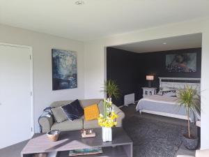 a living room with a couch and a bed at Christchurch - Port Levy, Bed & Breakfast in Port Levy