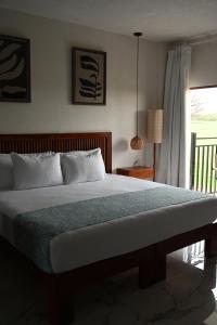 a bedroom with a large bed with a window at Hotel Casa del Rio in Santiago Tuxtla