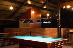a pool table in the middle of a room with lights at Camp Thuduwa Udawalawe in Udawalawe