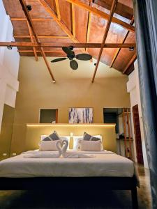 a bedroom with a bed with a ceiling fan at Hazel's Suites in Dauin