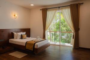 a bedroom with a bed and a large window at Camp Thuduwa Udawalawe in Udawalawe