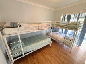 two bunk beds in a room with wooden floors at Mountain View Hat Head - Bring your own linen. in Hat Head