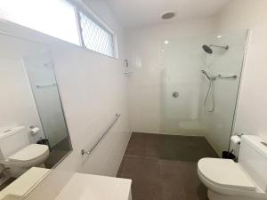 a white bathroom with a shower and a toilet at Mountain View Hat Head - Bring your own linen. in Hat Head +13 photos