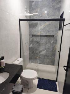 a bathroom with a shower and a toilet and a sink at Gk-Hospedagem in Foz do Iguaçu
