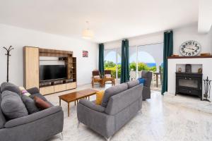 a living room with two couches and a television at Panorama Villa in Pomos