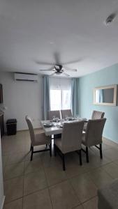 a dining room table with chairs and a ceiling fan at Casa León Cerca del Aeropuerto Internacional y Parques Industriales, Facturamos in Monterrey
