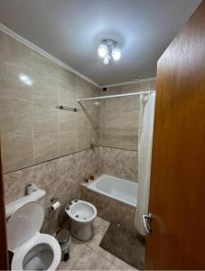 a bathroom with a toilet and a bath tub at Departamentos en Chivilcoy in Chivilcoy +13 photos