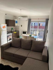 a living room with a couch and a kitchen at Departamentos en Chivilcoy in Chivilcoy