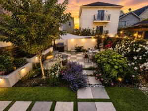 a garden with a table and chairs and flowers at Garden Oasis 3BR 15 min FIFA World Cup MetLife Std in Harrison