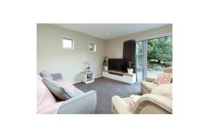 a living room with two couches and a tv at Alpine Nook in Methven's Heart, Walk to Town in Methven
