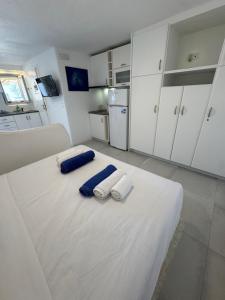 a large white room with two towels on a bed at Rineia Complex by Live&Travel in Mikonos