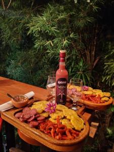 a table with a bottle of wine and a plate of food at Bunker de niker in Puerto Maldonado