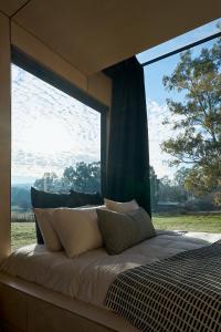 a bed in a room with a large window at Nestled Cabins in Verdun