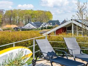 a group of chairs and a surfboard on a deck at Luxury Retreat in Hejlsminde in Hejls