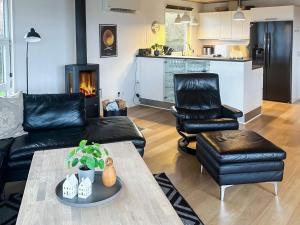 a living room with a couch and chairs and a fireplace at Luxury Retreat in Hejlsminde in Hejls