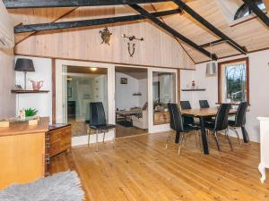a living room with a dining room table and chairs at Charming cottage near forest in Farsø in Farsø