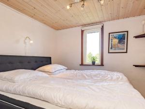 a bedroom with a large white bed with a window at Charming cottage near forest in Farsø in Farsø