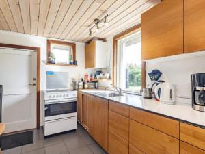 a kitchen with wooden cabinets and a white refrigerator at Charming cottage near forest in Farsø in Farsø +18 photos