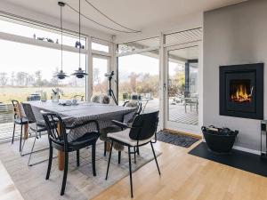 a dining room with a table and a fireplace at sunny Cottage with Spa facility in Gedser