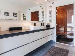 a white bathroom with a sink and a mirror at sunny Cottage with Spa facility in Gedser +37 photos