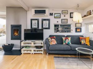 a living room with a couch and a flat screen tv at sunny Cottage with Spa facility in Gedser