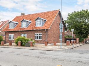 a brick house with an orange roof on a street at Charming Stay in Ringkobing in Ringkøbing