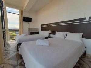 a hotel room with two beds and a television at Hotel Valle Verde in Tarapoto