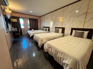 a hotel room with two beds with white sheets at One World Hotel in Kulai
