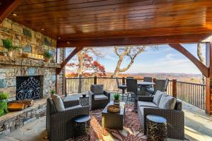 an outdoor patio with chairs and a fireplace at Bailey's Creek Lodge in Lenoir