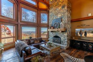 a living room with a couch and a stone fireplace at Bailey's Creek Lodge in Lenoir