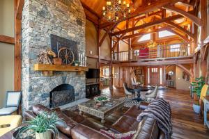 a large living room with a large stone fireplace at Bailey's Creek Lodge in Lenoir