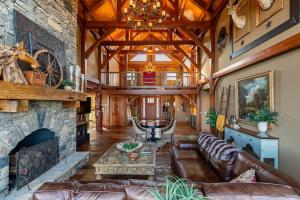 a living room with a stone fireplace and leather couches at Bailey's Creek Lodge in Lenoir +43 photos