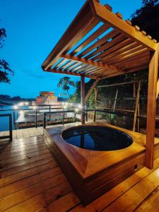 a hot tub on a deck with a wooden pergola at Bunker de niker in Puerto Maldonado