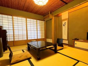 a room with a table and a chair in it at Yuzuya Ryokan - Adult Only in Kyoto