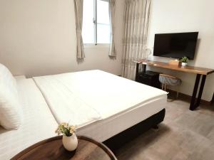 a bedroom with a bed and a desk and a television at 成功66民宿 Success 66 Guest House in Taitung City