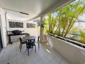 a balcony with a table and chairs and a piano at Jubilee Apartment 03 - Bring your own linen in South West Rocks