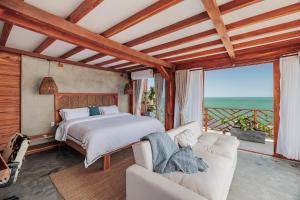a bedroom with a bed and a couch at Jaguar Beachfront Ecohotel & Spa in Santa Marta