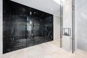 a elevator lobby with a black marble wall at 포항시티호텔 in Pohang