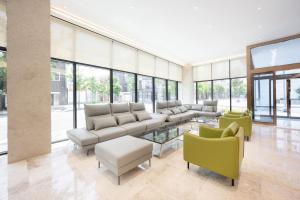 a living room with couches and chairs and windows at 포항시티호텔 in Pohang
